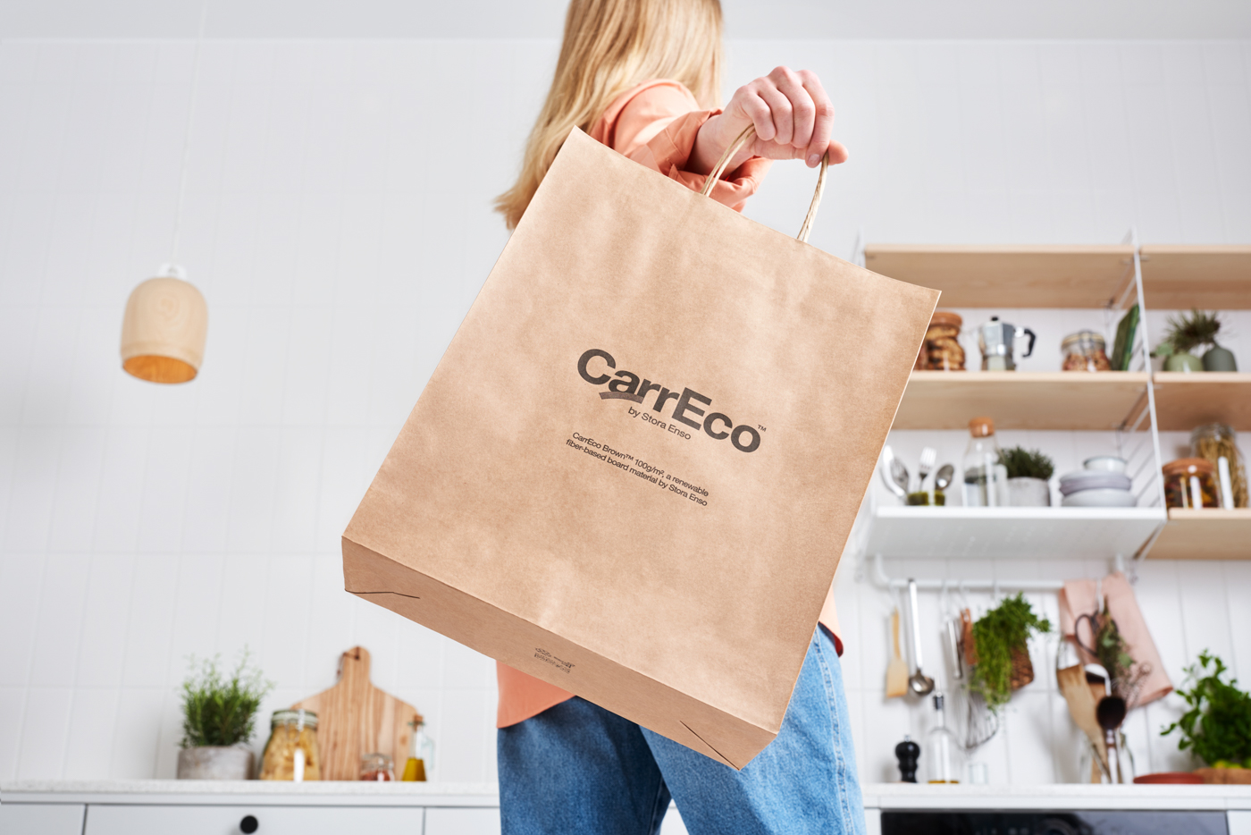 Henkilö kantaa ekologisen CartEco-paperikassin keittiössä.