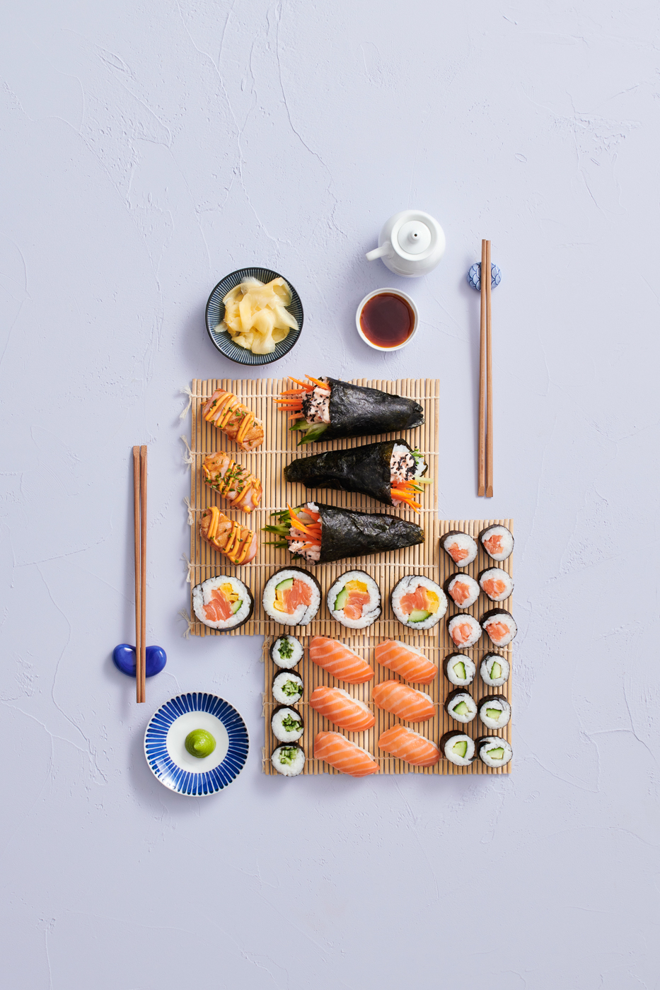 Sushi-lajitelma bambumatolla: maki- ja nigiri-sushi, soijakastiketta, wasabia sekä marinoitua inkivääriä.