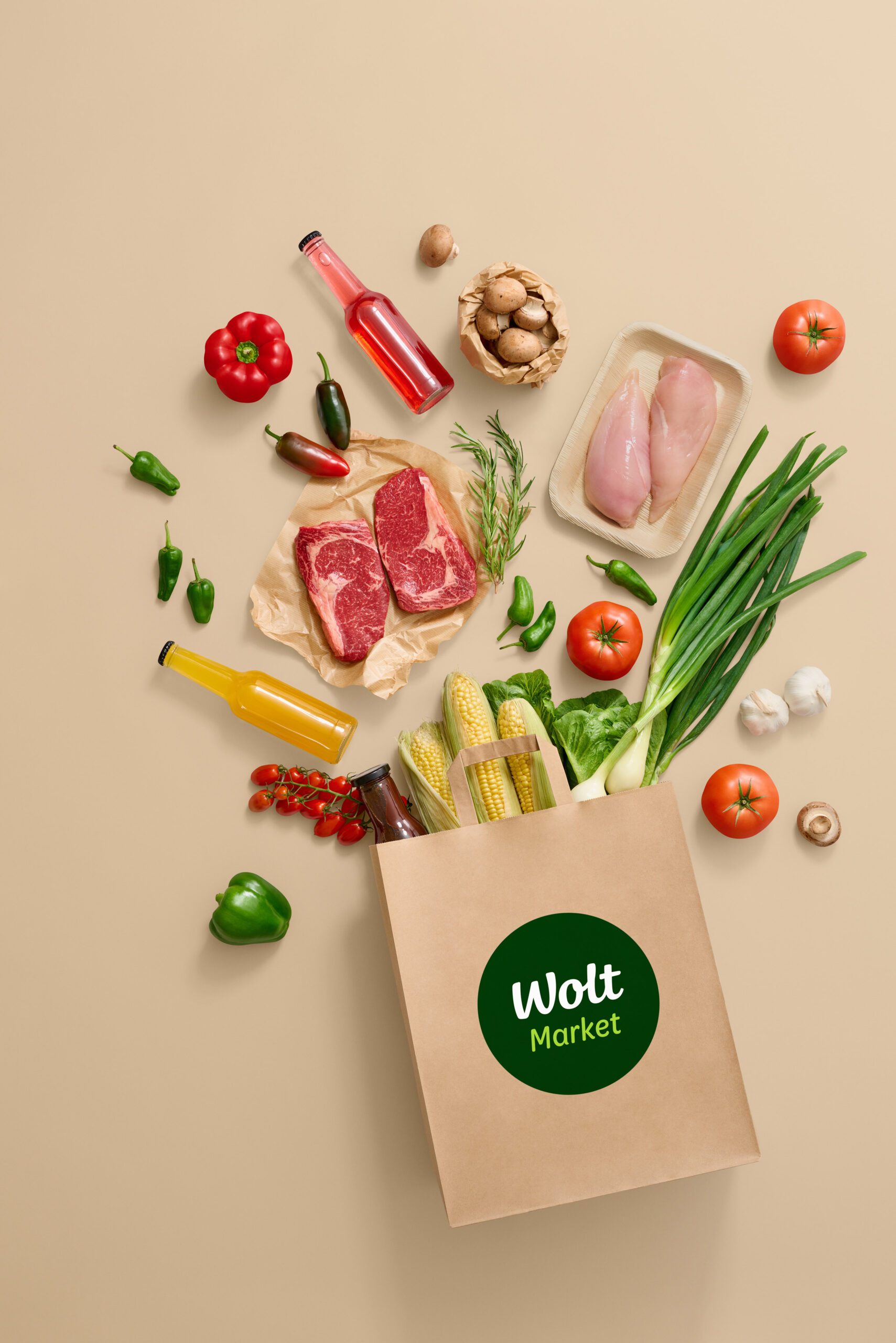 Monipuolinen ruokakori: naudan pihvejä, kananfileitä, vihanneksia (paprika, tomaatti), sienet, yrttiä – ja Wolt Market -kassi.